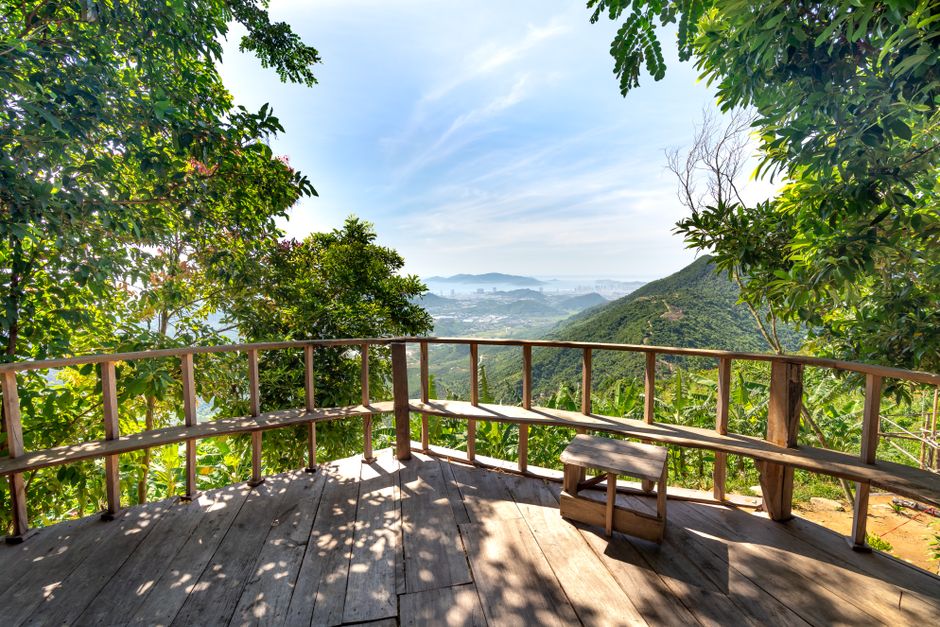 Balcón de madera con vista al valle verde y las montañas
