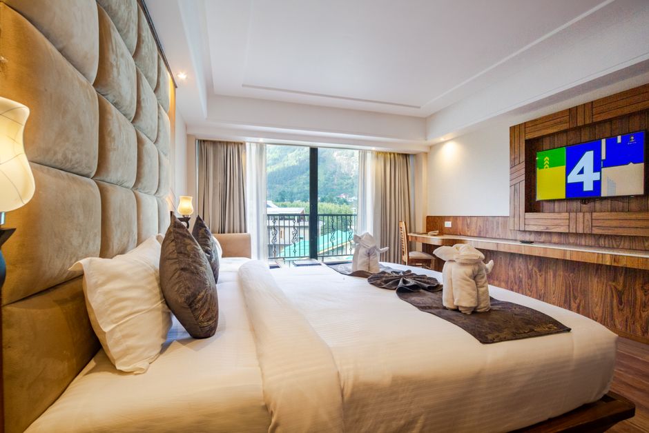 Habitación con cama doble y salida al balcón con vista a la montaña
